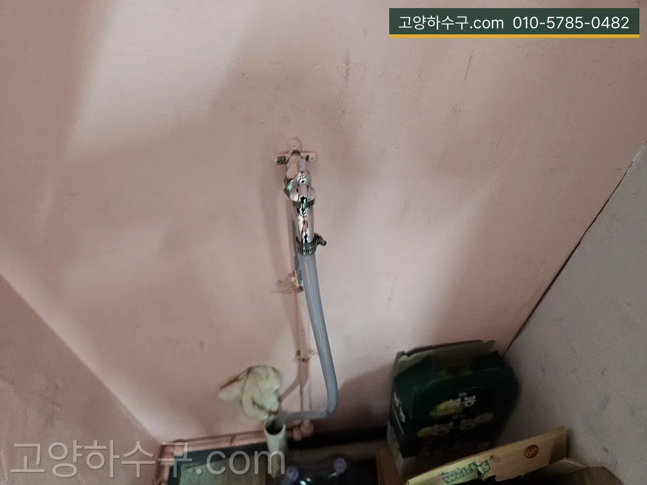 베란다 벽 수전에서 세탁기로 이어지는 급수 호스 연결부